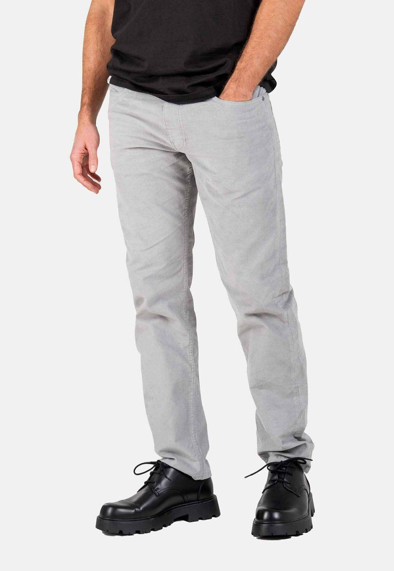 Light gray corduroy pants with a straight cut, featuring side pockets and slight wrinkling, paired with black lace-up boots.