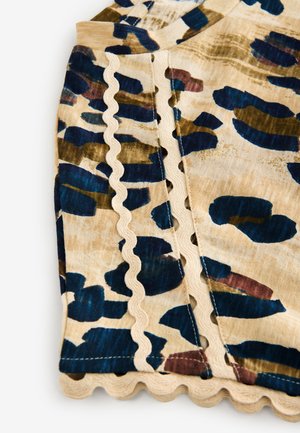 Többszínű blúz bézs alapon sötétkék és zöld absztrakt mintákkal. Hullámos élű varrások teszik részletgazdaggá.