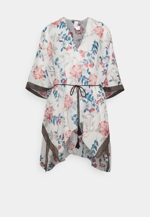 Top blanco estilo kimono con flores rosas y azules, ribete marrón en las mangas y el dobladillo, y un cinturón trenzado negro en la cintura.