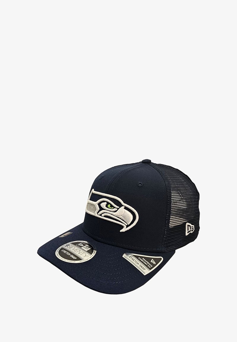 Casquette de baseball bleu marine avec un dos en filet, arborant un logo brodé blanc des Seattle Seahawks et des étiquettes en tissu sur le bord avant.