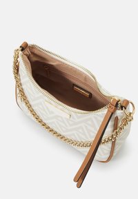 Sac à main compact beige avec un motif géométrique, quincaillerie dorée et une chaîne amovible. Intérieur doublé avec un compartiment zippé.