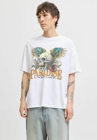 Hvid kortærmet t-shirt med en farverig grafik af et kranium med vinger og slanger, samt teksten "PARADISE UNKNOWN" i fed orange.