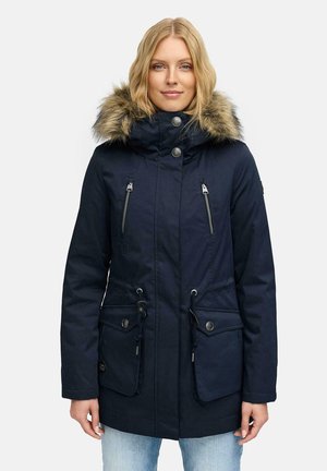 Navy blue parka made of fabric with faux fur trim on hood. Features two zippered chest pockets, adjustable drawstrings, and snap closure.