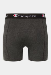Sivi pamučni bokserice s crnim elastičnim pojasom na kojem se nalazi bijeli "Champion" logo. Glatka tekstura i prilagođeni dizajn.