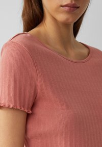 Helles pinkes Top aus strukturiertem Stoff mit vertikalen Rippungen, rundem Ausschnitt und kurzen Ärmeln mit gewellten Kanten.