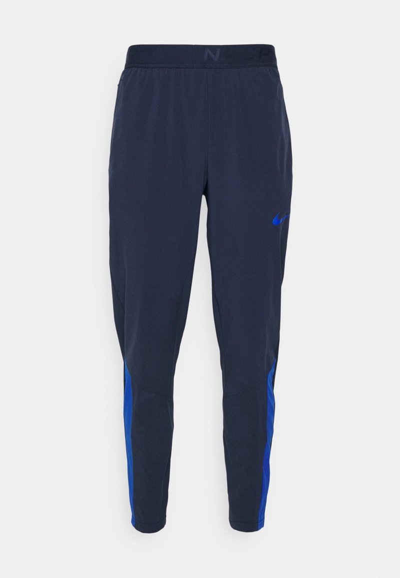 Herre træningsbukser i marineblå med smalle ben, elastisk talje og blå sideaccenter, med lille blå Nike swoosh-logo.