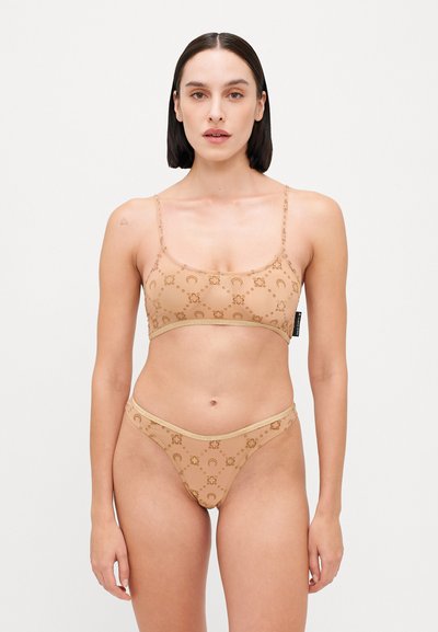 Ensemble de bikini nude avec un motif texturé en beige et or, comportant des fines bretelles et un design minimaliste. Tissu lisse, texture légère.