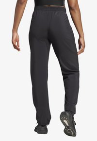 Schwarze Sporthosen mit elastischem Bund, schmal zulaufenden Beinen und einer glatten Textur. Verfügt über ein sportliches Design, das sich für aktive Kleidung eignet.