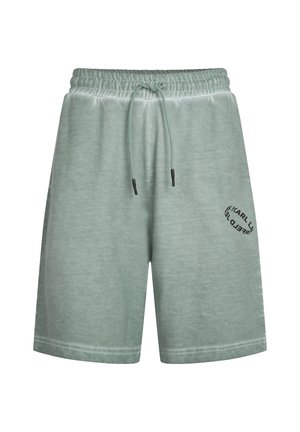 Šviesiai žali šortai, pagaminti iš minkštos medžiagos, su elastinga juosmens juosta ir raišteliu, bei spausdintu logotipu kairiajame šone.