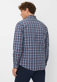 Blauw en bruin geruit shirt met lange mouwen, knoopmanchetten en een kraag; heeft een geblokt patroon en een gladde textuur.