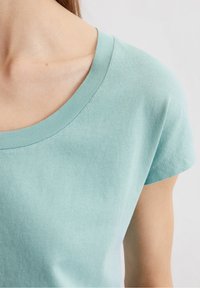 Ljust teal bomulls t-shirt med rund hals, korta ärmar och en mjuk yta, som framhäver enkelhet i designen.