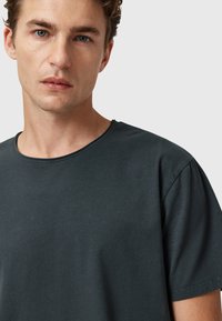 Dunkelgrau T-Shirt aus Baumwolle mit rundem Ausschnitt und kurzen Ärmeln, mit einer glatten Textur und minimalen Nähdetails.