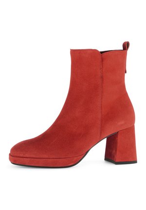 Red suede ankle boots with a square toe and a block heel. Features a pull tab and no visible hardware. Smooth texture throughout.