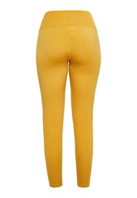 Leggings gialli con una texture liscia, vita alta e una vestibilità aderente. Senza motivi prominenti o accessori.
