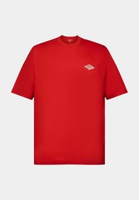 T-shirt in cotone rosso con maniche corte, collo a giro, e un piccolo logo a forma di diamante bianco sul lato sinistro del petto. Texture liscia, vestibilità regolare.