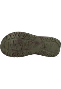 Green rubber shoe sole with textured tread patterns and multi-directional grip features. Includes brand name "Teva" embossed on the surface.