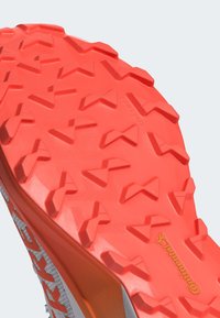 Suola di scarpa in gomma rossa con un motivo a zigzag, con il logo "Continental" in giallo, che migliora la presa e la trazione su varie superfici.
