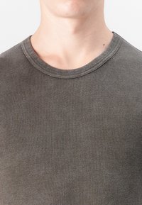 Dark gray ribbed cotton t-shirt with a round neckline, featuring a smooth texture and short sleeves, showcasing a close-fitting design.
