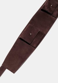 Rjav rjav antilopen pas z dvema majhnima žepoma s preklopom in gladko površino. Opremljen je s srebrno kovino in kontrastnim šivanjem vzdolž robov.