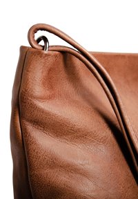 Brown leather handbag with textured surface, featuring a curved design and a sleek, rounded handle attached with a silver ring.