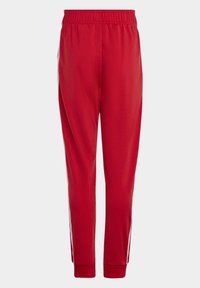 Rdeče atletske hlače z elastičnim pasom, ožjimi nogami in belimi stranskimi črtami. Tkanina je gladka z rahlim leskom.