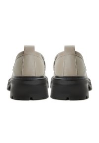 Scarpe in pelle grigia chiara con suola nera spessa, caratterizzate da una texture liscia e un design minimalista, mostrate in vista posteriore con linguette per il pull.