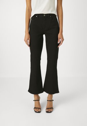 Jean évasé noir taille haute, en denim. Il présente des poches avant et deux boutons en métal à la ceinture.