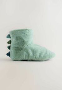 Pantofole verde menta morbide con punta arrotondata e risvolto corto. Presentano una texture soffice e tre accenti a punta multicolore sul retro.