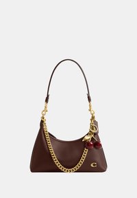Dark brown leather handbag with gold chain detail, cherry-shaped charm, and a small gold logo on a plain background.