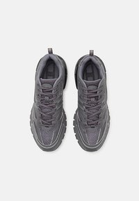 Šedé atletické boty z síťoviny a syntetických materiálů. Mají polstrovaný límec, texturovaný design a pryžovou podešev s protiskluzovým vzorem.