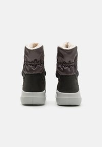 Schwarze und graue Stiefelknöchel mit einem gepolsterten Obermaterial, Kunstfellfutter und einer Gummisohle. Das Design umfasst elastische Akzente.