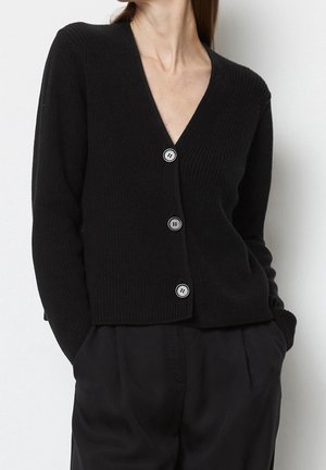 Cardigan noir à côtes avec un décolleté en V profond, featuring quatre grands boutons et une coupe décontractée. La texture semble douce et confortable.