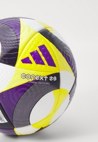 Ballon de football Adidas Conext 26, avec une surface texturée en jaune, violet et noir, ornée de motifs distinctifs et de marquages.