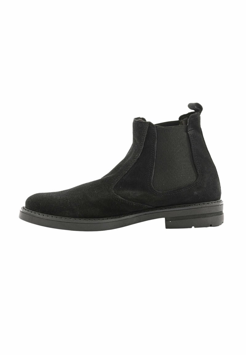 Stivale Chelsea in suede nero con pannelli laterali elasticizzati, finitura texture, punta arrotondata e tacco basso in gomma per stabilità.
