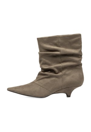 Bota de ante marrón suave hasta media pantorrilla con diseño holgado, punta puntiaguda y tacón bajo de estilo kitten.