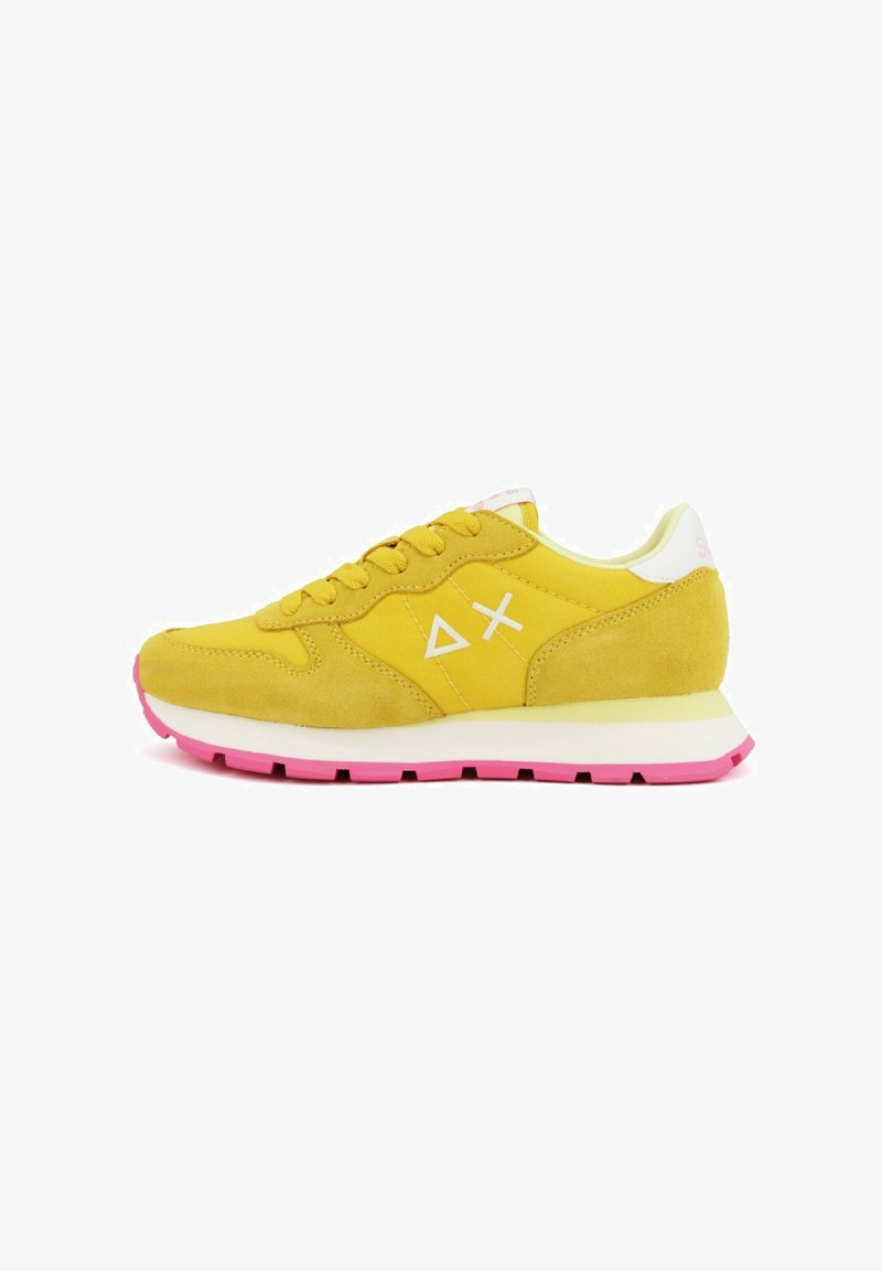 Gele suède sneaker met witte en roze accenten, ronde neus, vetersluiting, gevoerde zool en contrasterende roze rubberen buitenzool.