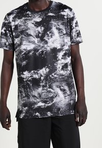 T-shirt med kort ärm i svart med grå abstrakta virvlar, tillverkad av andningsbart tyg. Rund halsringning och avslappnad passform. Matchas med svarta shorts.