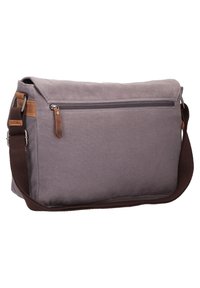 Borsa a tracolla in tela grigia con chiusura a patta. Presenta una tasca con zip, dettagli in pelle marrone e una tracolla regolabile.