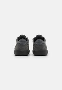 Adidași gri din suede cu o finisaj texturat, talpă din cauciuc, guler căptușit și logo-ul embosat "LAKAI" pe călcâi. Vedere din spate afișată.