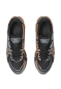 Czarne buty sportowe z siateczkową cholewką, teksturowanymi akcentami i pomarańczowymi detalami; zaokrąglony czubek, wyściełana podeszwa i sznurowane zapięcie.