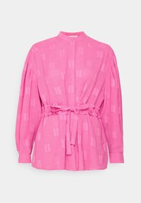 Blusa rosa in tessuto leggero con colletto, chiusura a bottoni, cintura elastica in vita e motivo testurizzato con strisce verticali.
