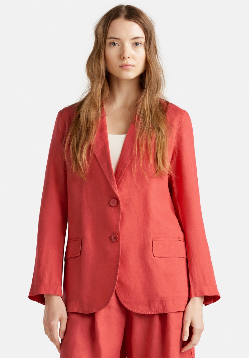 Červený lněný blazer s výstřihem do V, dvěma knoflíky a dvěma předními kapsami; lehká textura a mírně volný střih.