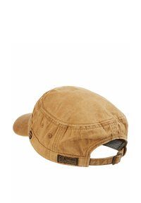 Brown cotton cap with a rounded top, curved brim, adjustable strap at the back, and a woven logo patch detail on the side.