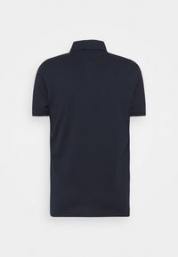 Polo bleu marine, à manches courtes, en tissu texturé, avec un col côtelé et un dos présentant un détail de couture en forme de V subtil.