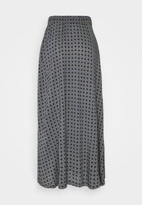 Jupe maxi en tissu bleu marine avec un motif circulaire répétitif en gris clair. Taille élastique, forme fluide, avec une texture lisse et légère.