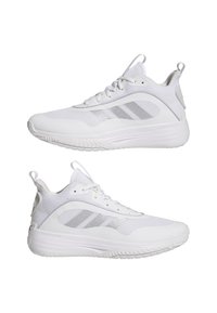 Paire de chaussures de sport blanches en tissu mesh, avec des bandes argentées, des lacets et des languettes, vues de côté sur un fond blanc.