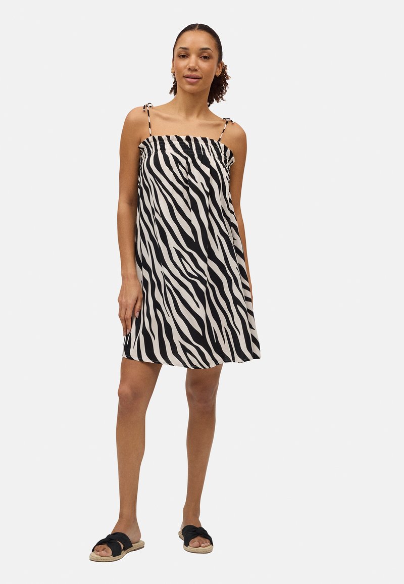 Vestido sin mangas de estampado de cebra en negro y beige, con un corpiño fruncido y tirantes ajustables. Tela suave.