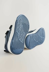 Zapatos azules con suelas de goma que presentan patrones de agarre texturizados. Diseñados con correas de velcro para un ajuste fácil y una apariencia moderna y elegante.