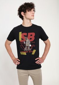 Černé bavlněné tričko s grafickým potiskem v červených a žlutých akcentem. Design obsahuje postavu skateboardisty a text "STREET STYLE".