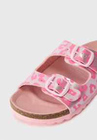 Ροζ σανδάλια με λεοπάρ σχέδιο, εξοπλισμένα με δύο ρυθμιζόμενες ιμάντες, ασημί εξαρτήματα και υφή στο πέλμα. Φόρος από φελλό και ροζ σόλα.